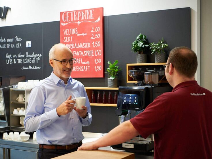 Service Techniker erklärt Kunden den Kaffeeautomaten
