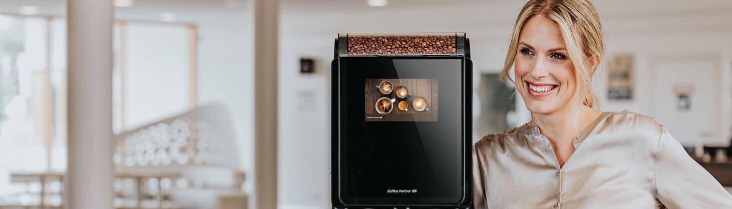 Frau neben Kaffeeautomaten-Modell Barista Compact