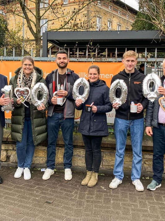 Kaffee Partner Mitarbeitende überreichen gemeinsam mit Geschäftsführer Jörg Baumgart eine Spende in Höhe von 10.000 Euro an die Osnabrücker Kindertafel. Entstanden im Rahmen der jährlichen Aktion „Kaffee Partner for Kids“.