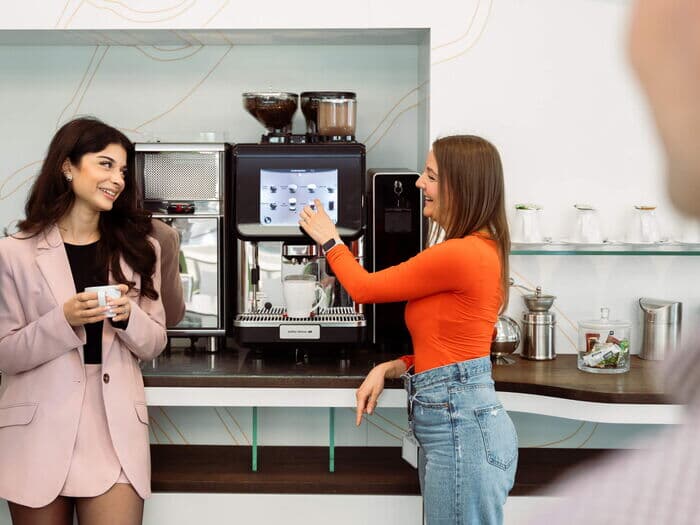 Zwei-frauen-interagieren-mit-ultima-duo-2-kaffeevollautomat