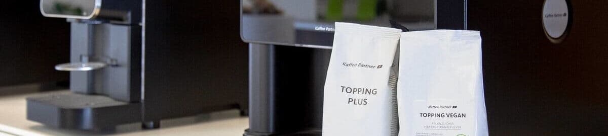 Topping-Packungen neben Kaffeevollautomat