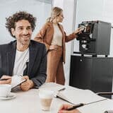 Kollegen-in-besprechung-mit-kaffeevollautomat