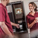 Cappuccino-wird-zubereitet-mitarbeiter-warten-am-kaffeeautomaten