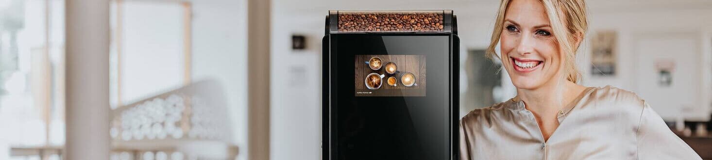 Frau neben Kaffeeautomaten-Modell Barista Compact